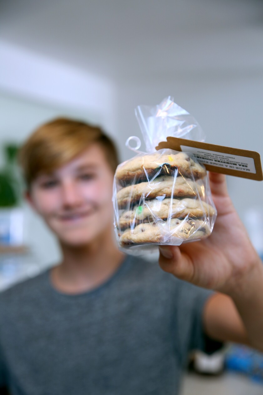 Costa Mesa cookie owner Jasper Rogers poses with a package of his signature Sea Monster cookies.