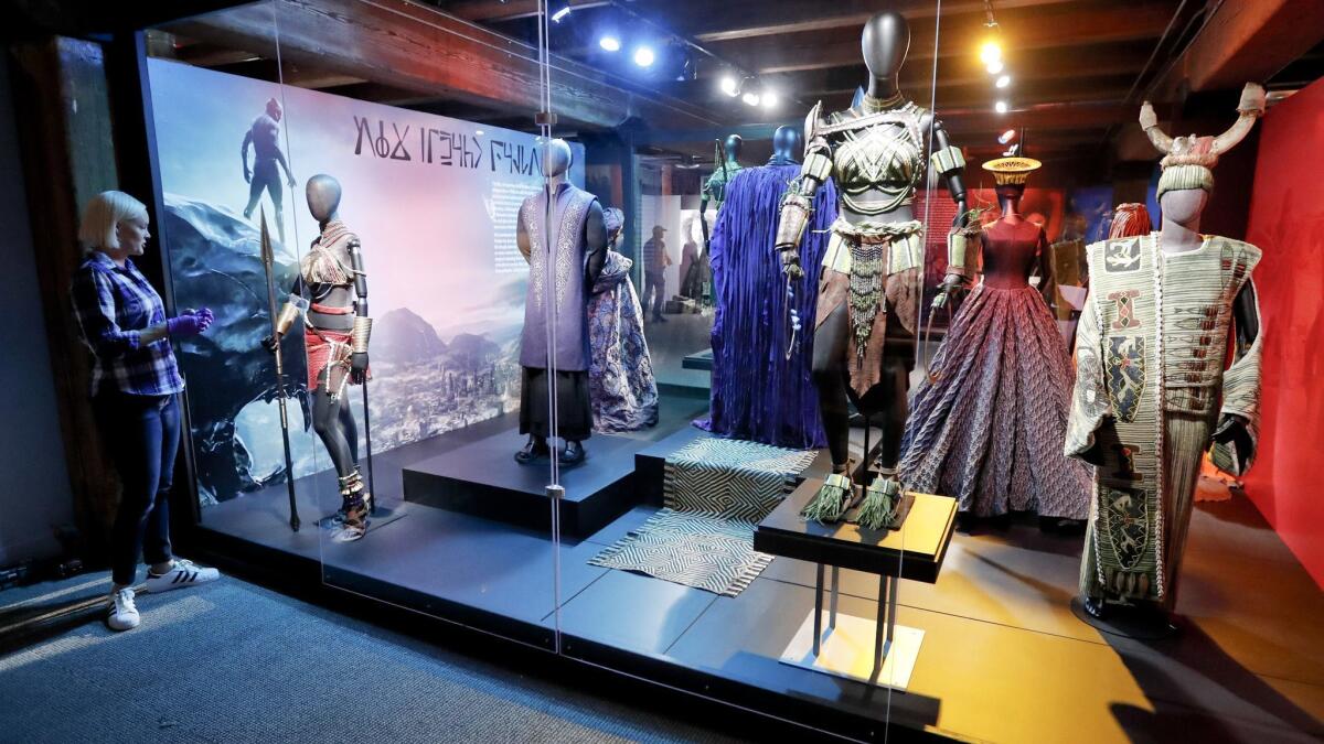 Courtney Beecraft checks on costumes from "Black Panther" before the opening of an exhibition of work by costume designer Ruth E. Carter at Pittsburgh's Sen. John Heinz History Center. The exhibition, "Heroes & Sheroes," opened Aug. 25 and explores Carter's career.