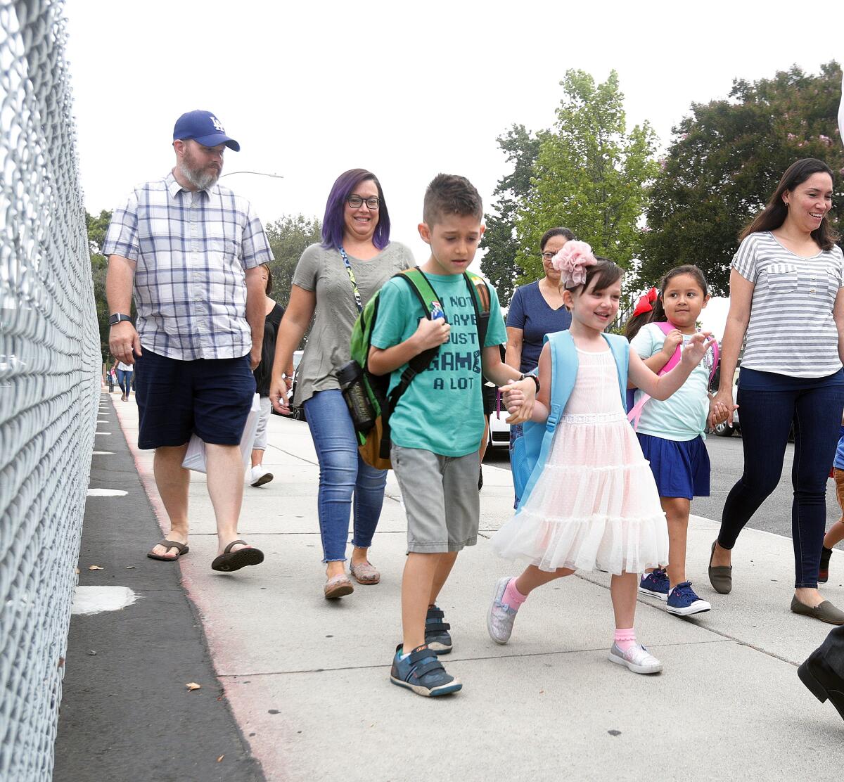 Liam, 8, and Maisie Kolpek, 5, walk hand-in-hand with their parents, Kristofer and Erin, on their way to the first day of classes at Bret Harte Elementary School on Monday.