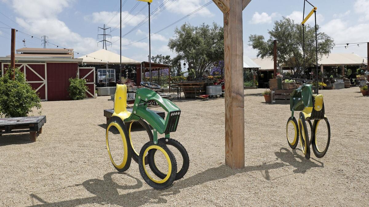Children can swing on farm tractor truck swings at Manassero Farms in Irvine.