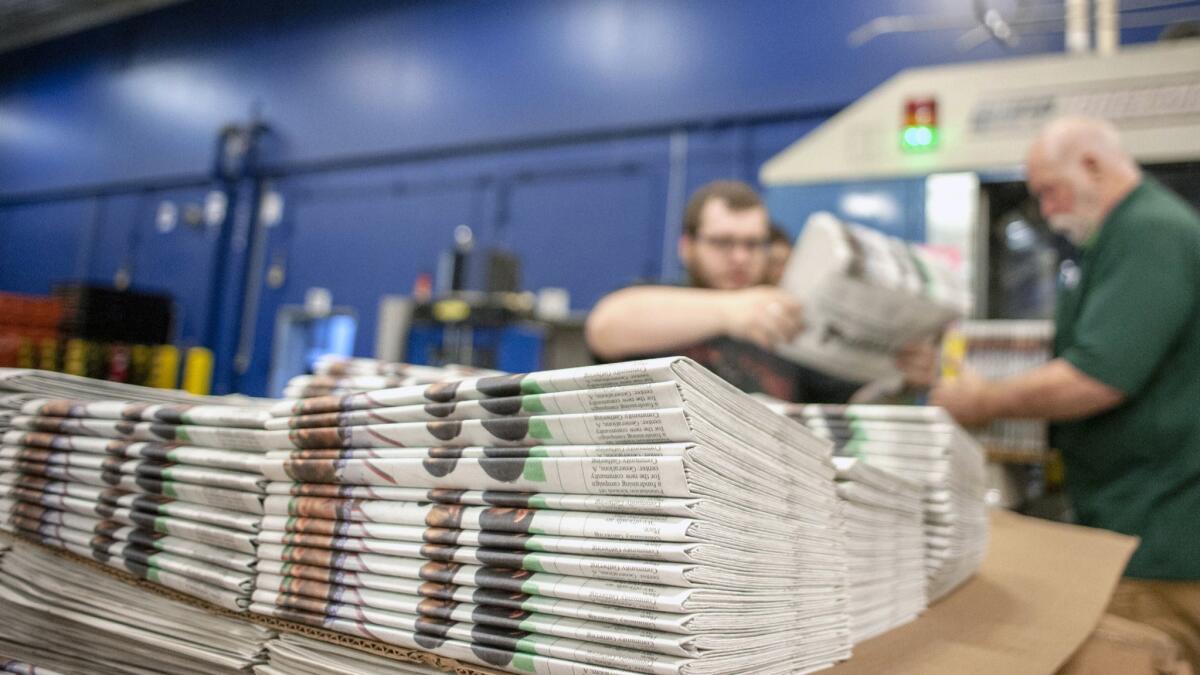 Workers stack newspapers at the Janesville Gazette Printing & Distribution plant in Janesville, Wis., in April. Tariffs had targeted Canadian newsprint.