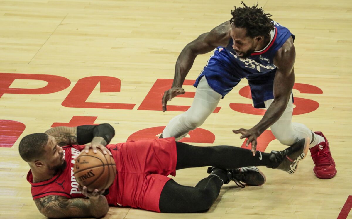 Portland's Damian Lillard, left, is covered by Clippers guard Patrick Beverley.