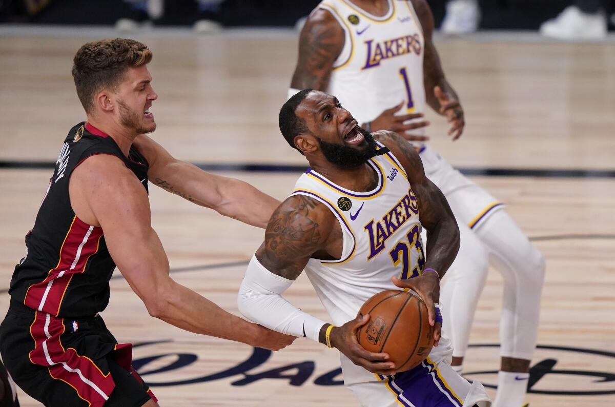 Lakers forward LeBron James is fouled on a drive by Heat center Meyers Leonard during Game 3.