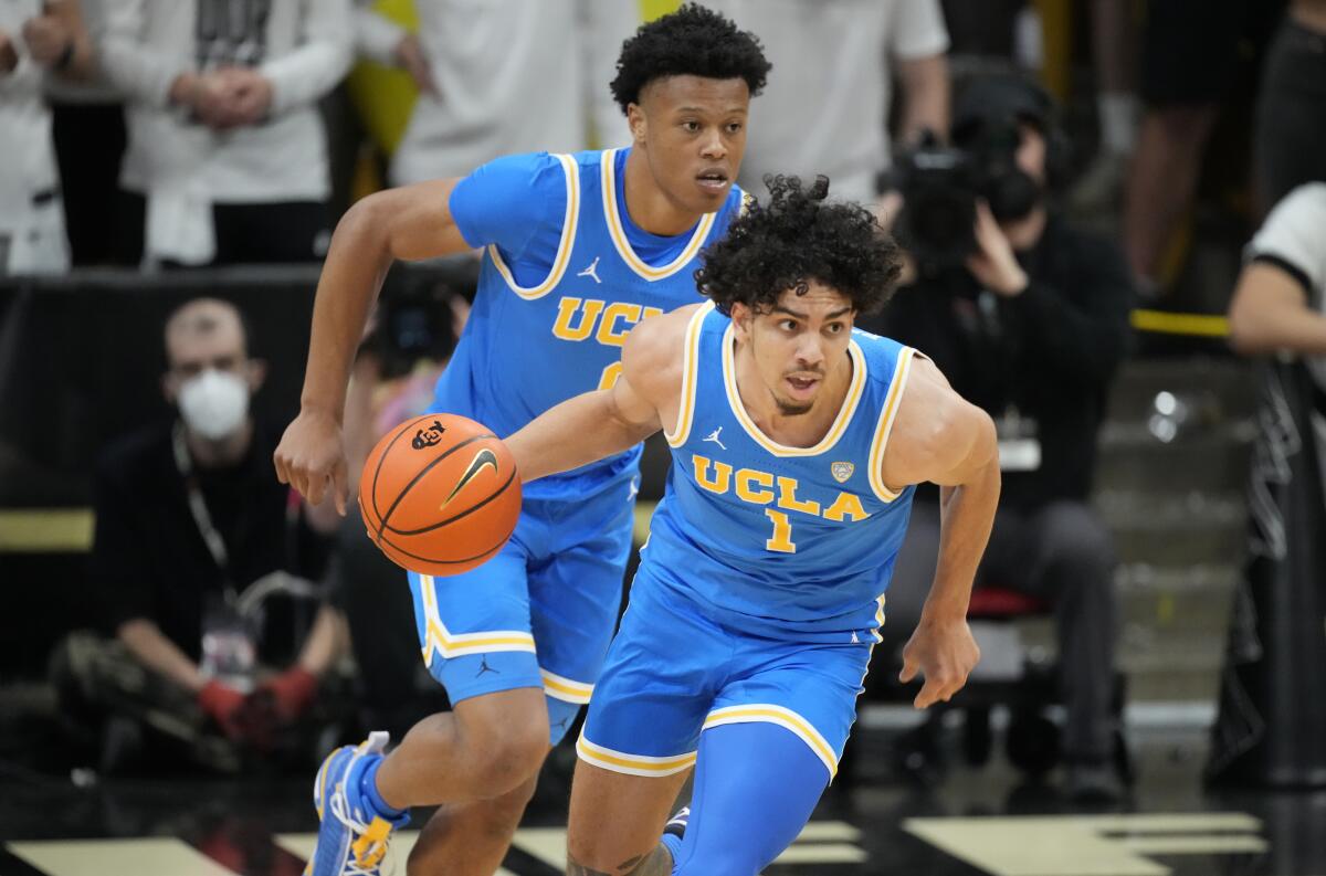 Jules Bernard handles the ball as UCLA teammate Jaylen Clark follows him.