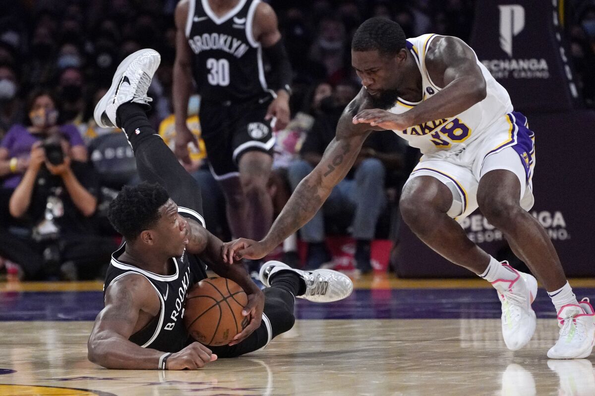 Brooklyn Nets forward Devontae Cacok goes after a loose ball in front of Lakers guard Chaundee Brown.