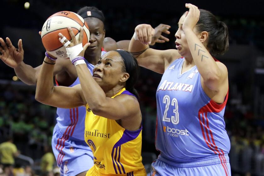 Sparks guard Temeka Johnson drives between Atlanta's Shoni Schimmel (23) and Aneika Henry in the first half of their game Thursday afternoon at Staples Center.
