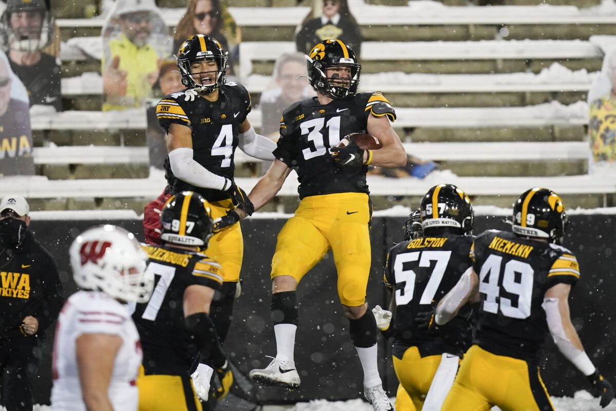 Iowa linebacker Jack Campbell (31) celebrates with teammate Dane Belton (4) after intercepting a pass during the second half of an NCAA college football game against Wisconsin, Saturday, Dec. 12, 2020, in Iowa City, Iowa. Iowa won 28-7. (AP Photo/Charlie Neibergall)