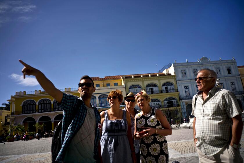 A tour guide directs tourists in Havana, Cuba