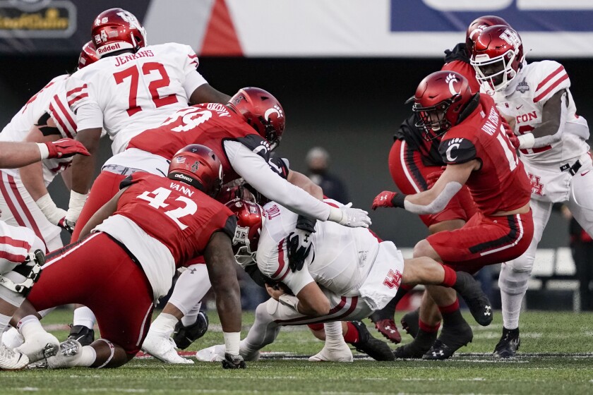 Houston quarterback Clayton Tune, center right, is sacked by Cincinnati's Joel Dublanko during the first half of the American Athletic Conference championship NCAA college football game Saturday, Dec. 4, 2021, in Cincinnati. (AP Photo/Jeff Dean)