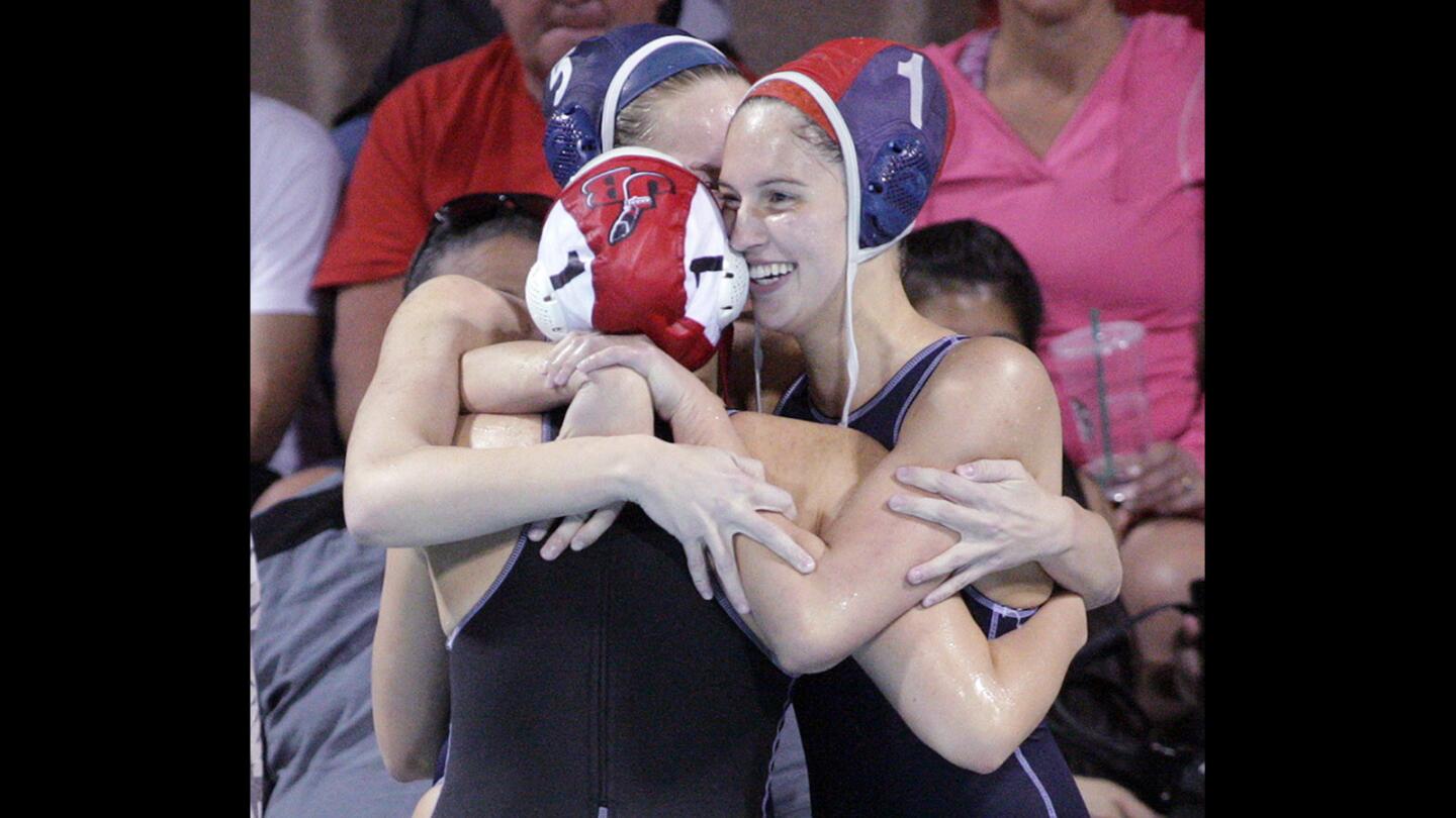 Crescenta Valley's goalie Mackenzie Drewe and teammate Rachel Ward hug Burroughs goalie Kate Wilke after CV won the game in the Pacific League girls' water polo championship at Burbank High School on Thursday, Feb. 11, 2016.