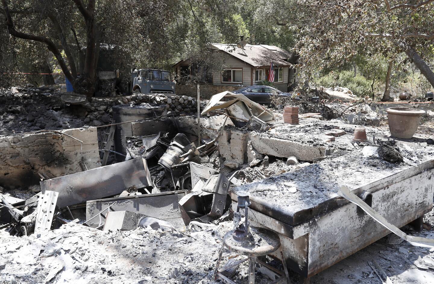 The Trabuco Canyon home of arson suspect Forrest Gordon Clark, 51, stands untouched amid charred remains in his neighborhood.