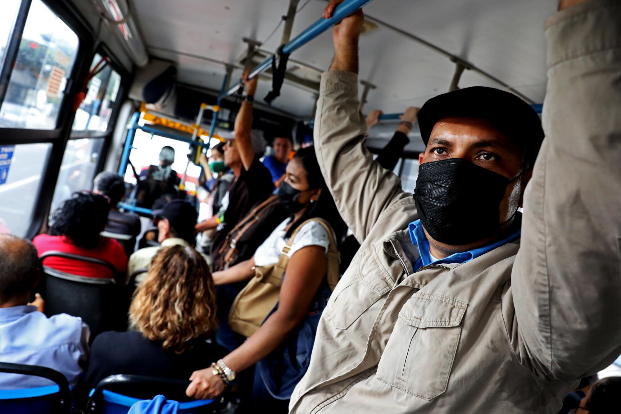 Man stands in a crowded bus.