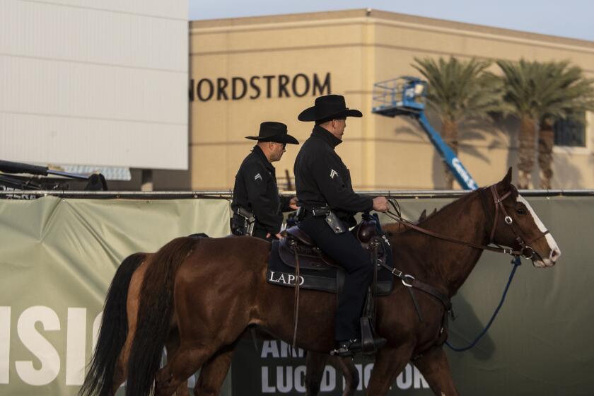 CANOGA PARK, CA - December 06 2021: LAPD mounted unit officers Daniel, right, and Morales, left, patrol the Westfield Topanga shopping mall on Monday, Dec. 6, 2021 in Canoga Park, CA. (Brian van der Brug / Los Angeles Times