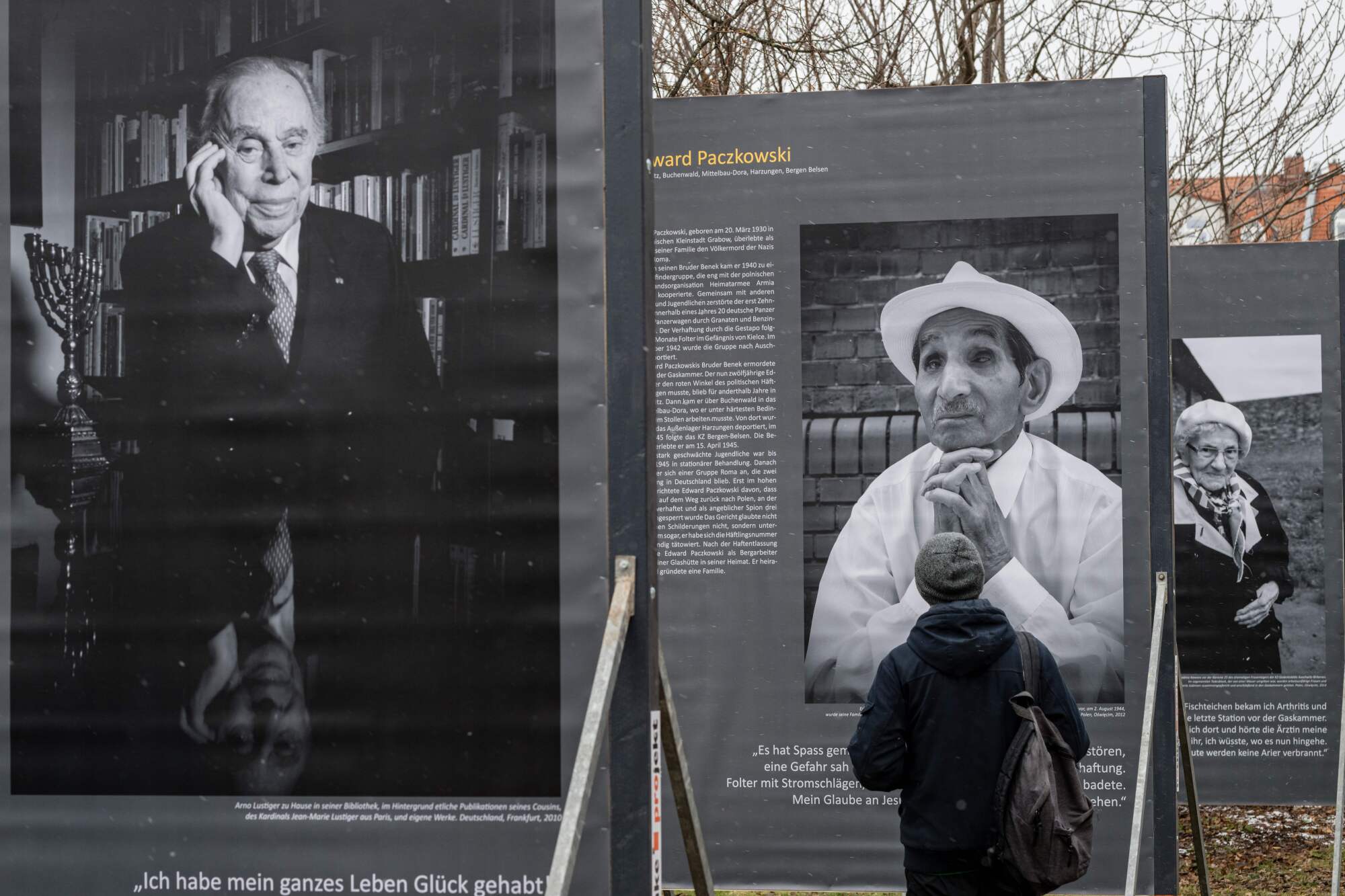 A visitor looks at portraits of Holocaust survivors in the exhibition "Concentration Camp Survivors"