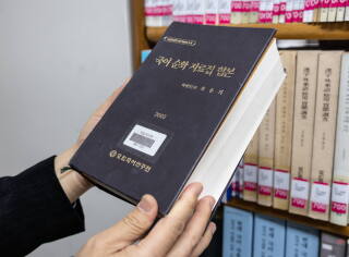 Kim Hyeong-bae, a senior researcher, takes out a book that descri
