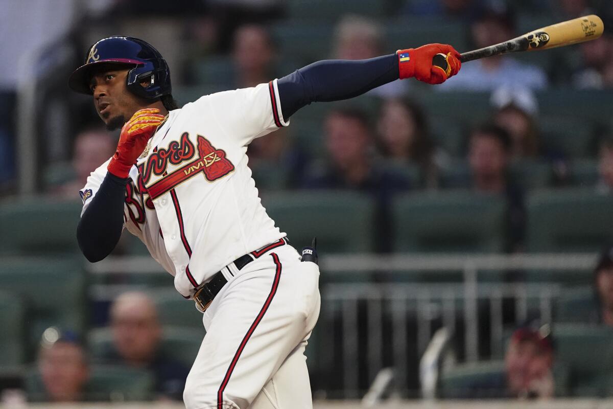 Atlanta Braves' Ozzie Albies follows through on a two-run double during the second inning of the team's baseball game against the Washington Nationals on Tuesday, April 12, 2022, in Atlanta. (AP Photo/John Bazemore)