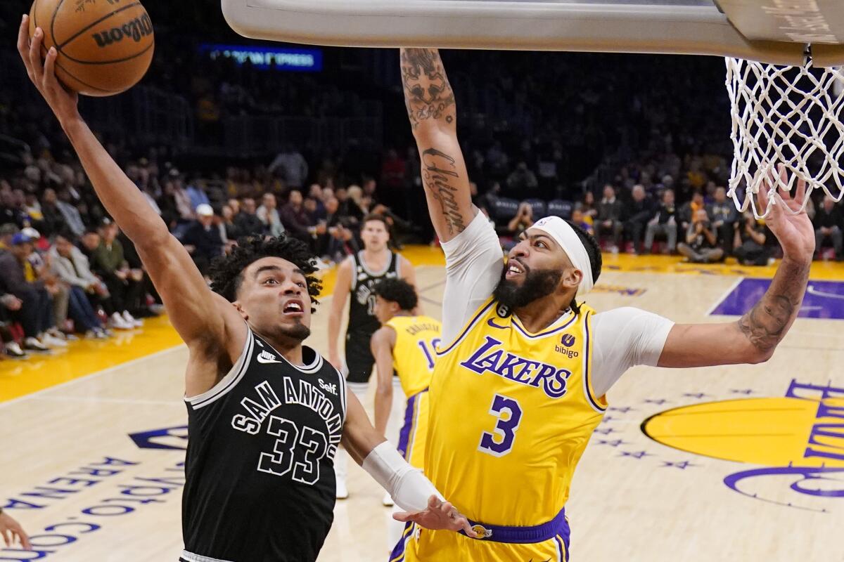 Lakers forward Anthony Davis tries to block a shot by Spurs guard Tre Jones.