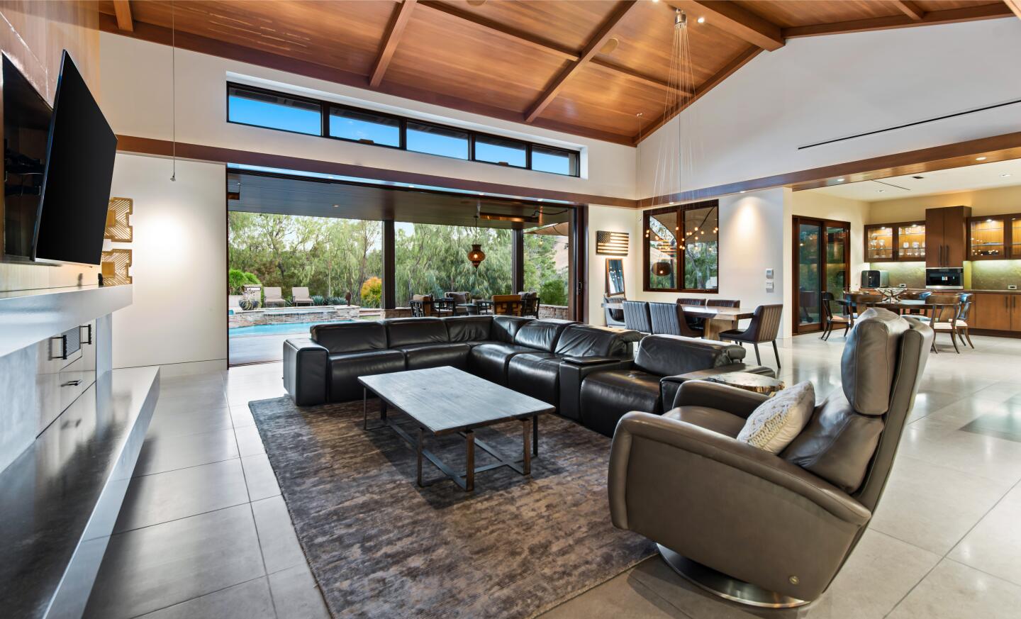 The living room has furniture, a wooden ceiling and a rug.