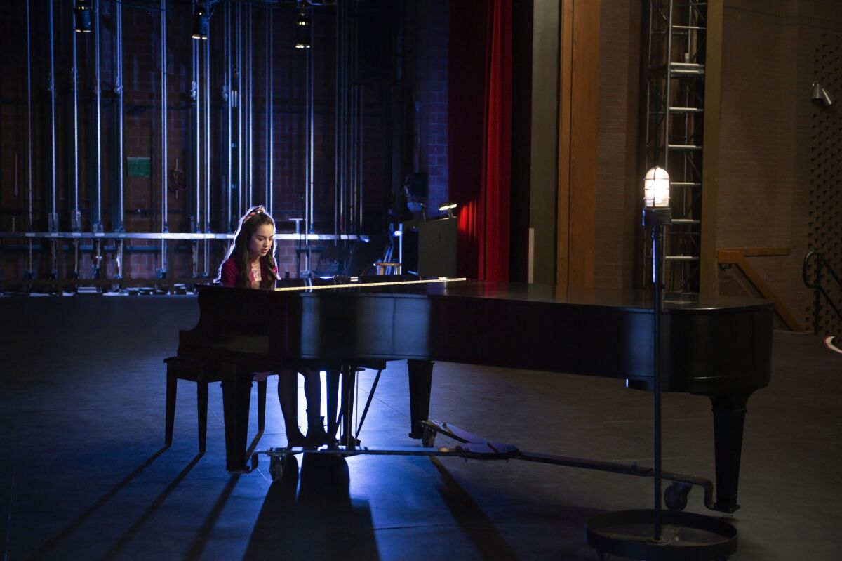 A woman playing piano on a stage