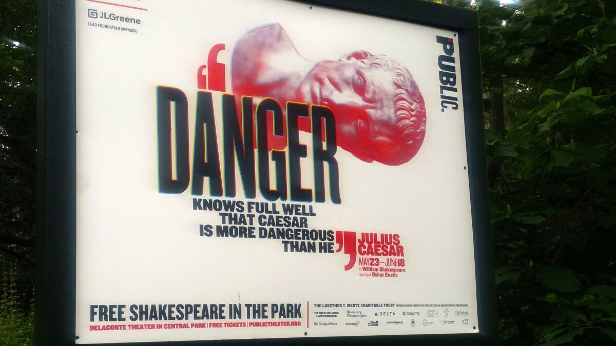 A sign promotes the Public Theater's production of "Julius Caesar" in New York's Central Park.