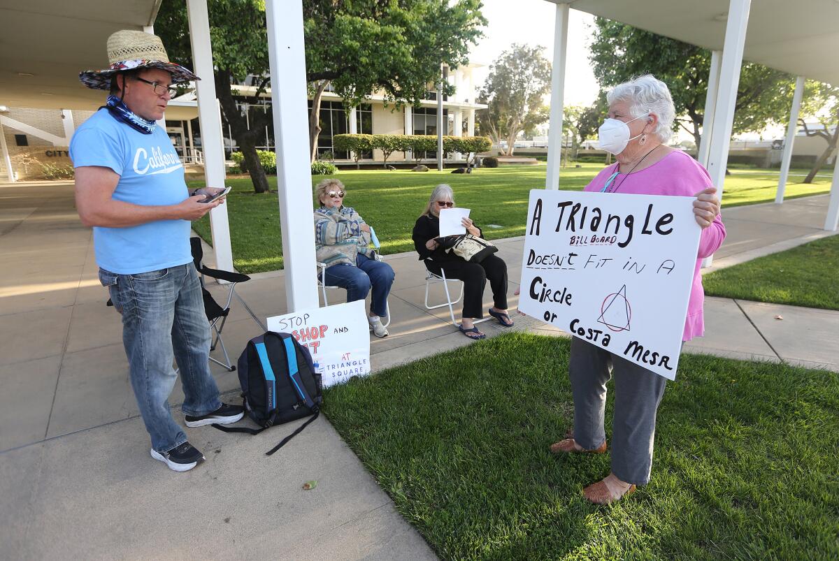 Residents outside Costa Mesa City Hall on Monday follow the progress of the city Planning Commission meeting. 
