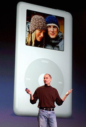 Jobs introduces the iPod Photo, which has a color screen to display photos and slide shows accompanied by music. The 60-gigabyte model could hold 25,000 photos and sold for $599; a 40-gigabyte model sold for $499.