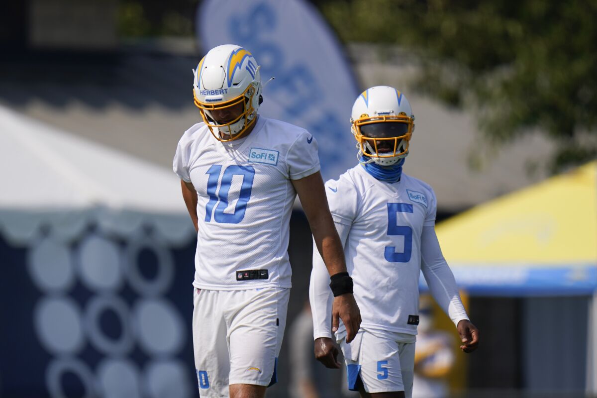 Chargers quarterbacks Justin Herbert, left, and Tyrod Taylor during camp practice last month.