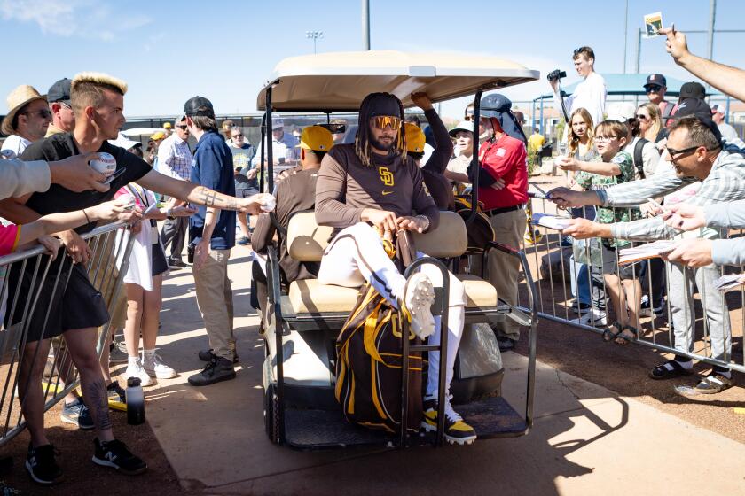 Peoria, AZ - February 17: Fernando Tatis Jr., center, sits on a golf cart as fans plead for more autographs during spring training workouts at the Peoria Sports Complex on Saturday, Feb. 17, 2024 in Peoria, AZ. (Meg McLaughlin / The San Diego Union-Tribune)