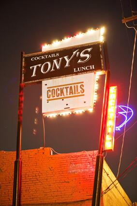 The neon sign outside of Tony's bar beckons patrons with the sweet promise of cocktails.