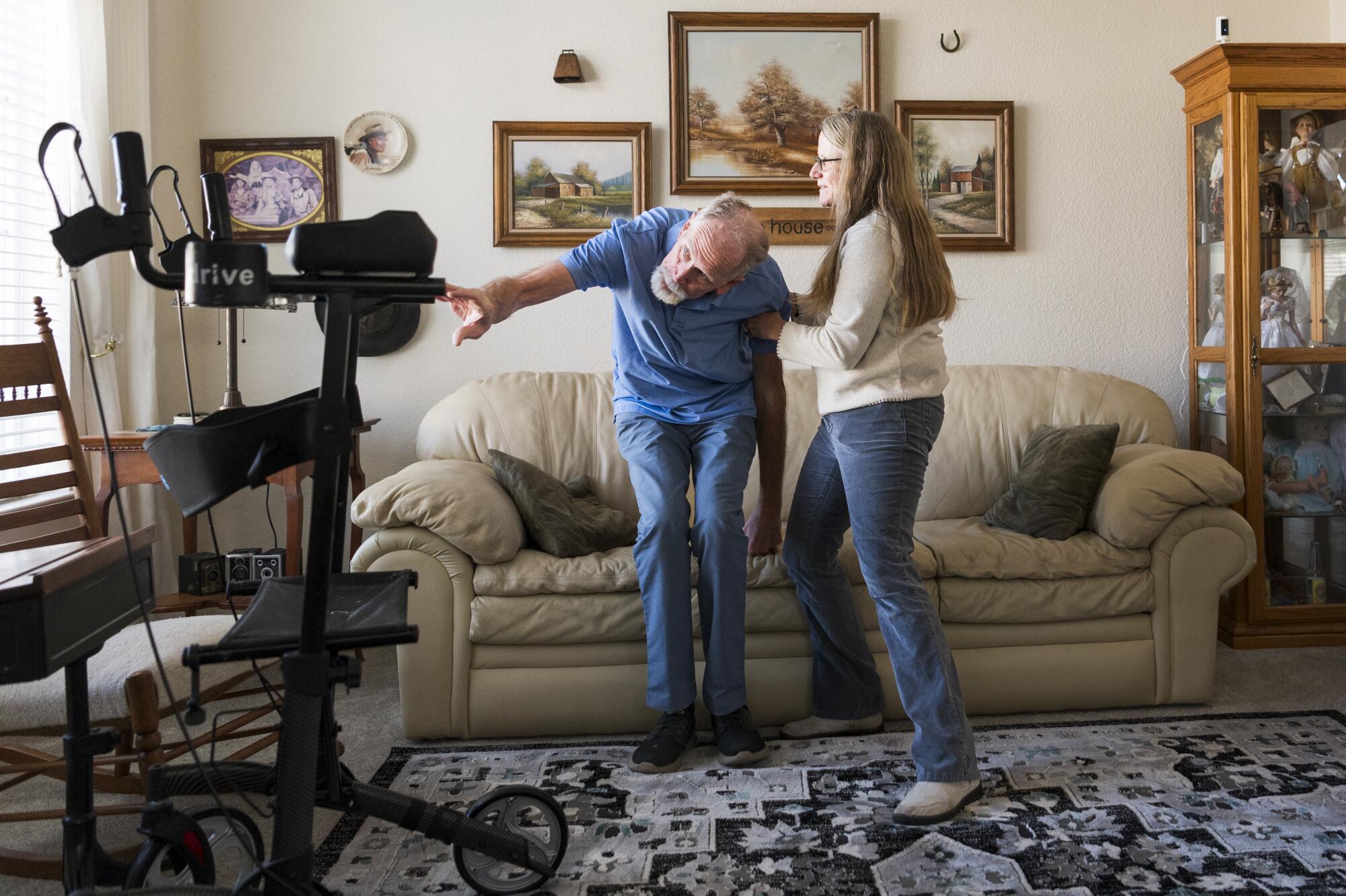 Tammie Mund helps her husband, Gary, to his feet at their home in Sparks, Nev. 