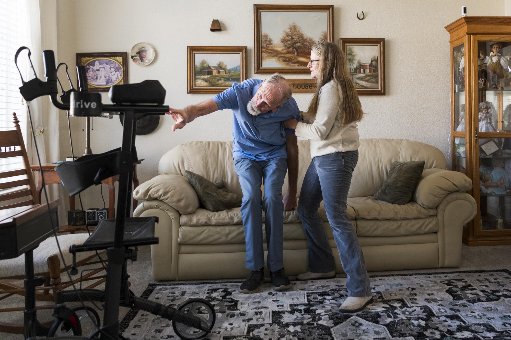 Tammie Mund helps her husband, Gary, to his feet at their home in Sparks, Nev.