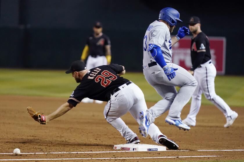 Los Angeles Dodgers' Max Muncy, front right, reaches first base safely as Arizona Diamondbacks starting pitcher Merrill Kelly (29) is unable to make a catch on a throwing error by Diamondbacks' Geraldo Perdomo during the third inning of a baseball game Thursday, April 6, 2023, in Phoenix. (AP Photo/Ross D. Franklin)