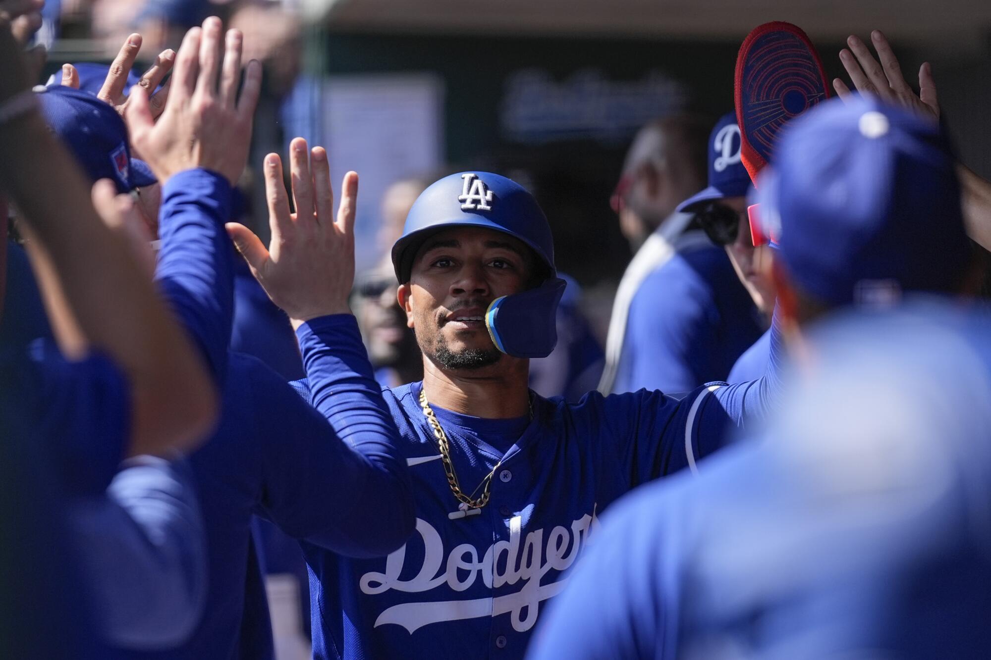 Dodgers'dan Mookie Betts takım arkadaşlarına beşlik çakıyor ve golün ardından kutlama yapıyor.