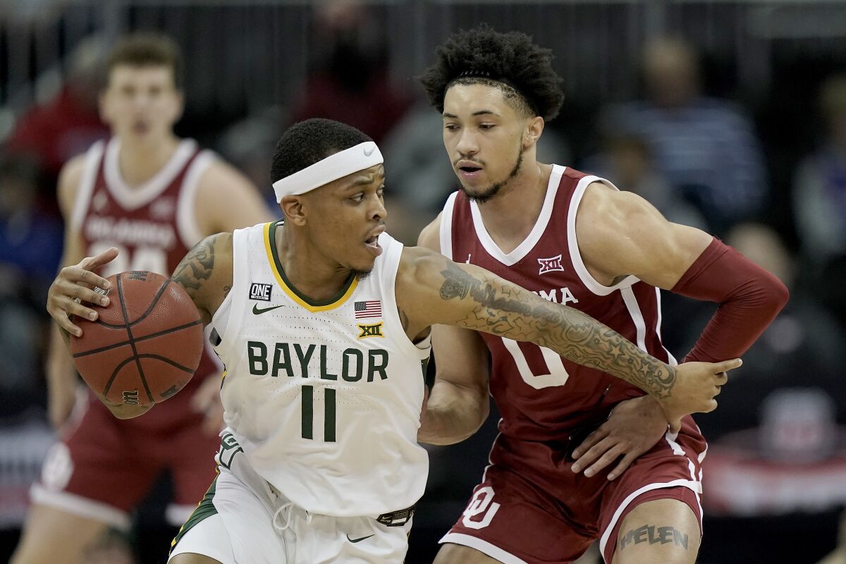 Baylor guard James Akinjo (11) drives past Oklahoma guard Jordan Goldwire during a game on March 10.