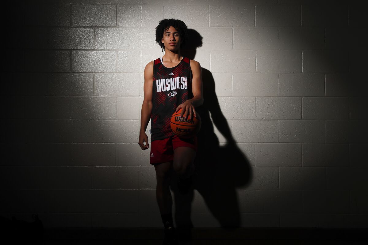 Corona Centennial guard Jared McCain poses for a photo while holding a basketball with his left hand.