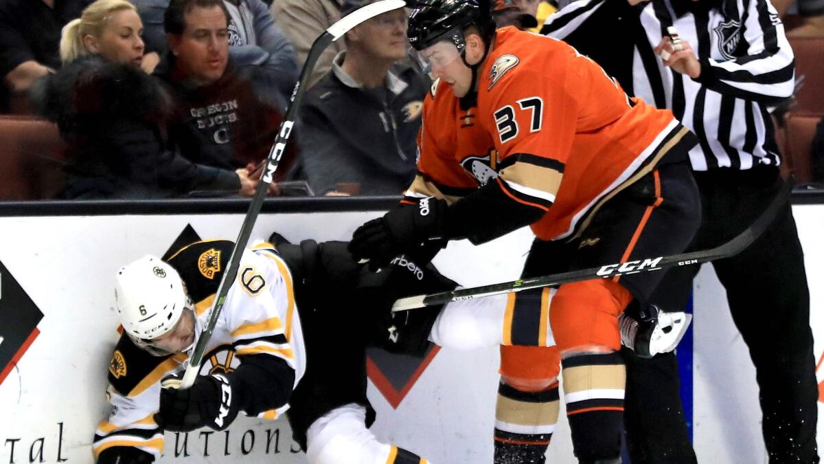 Ducks forward Nick Ritchie checks Bruins defenseman Colin Miller during the first period of a game Wednesday night at Honda Center. The Ducks won, 5-3.