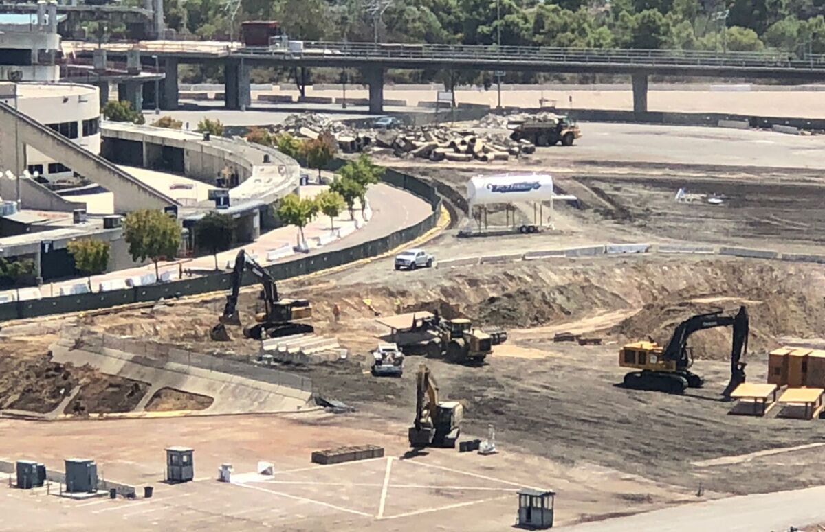Some excavation has begun in parking lot sections F1 and G1, while debris piles up in J1 near the trolley bridge.