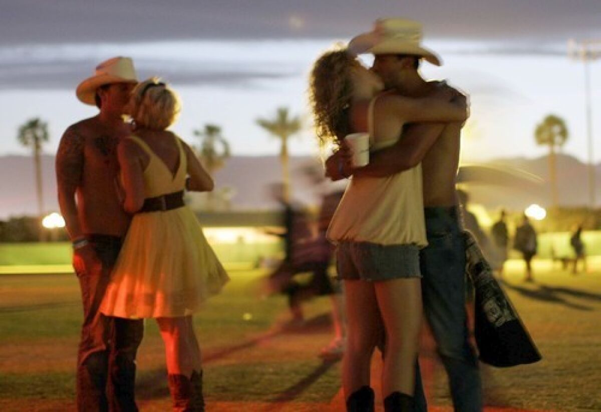 Couples kiss at a music festival.