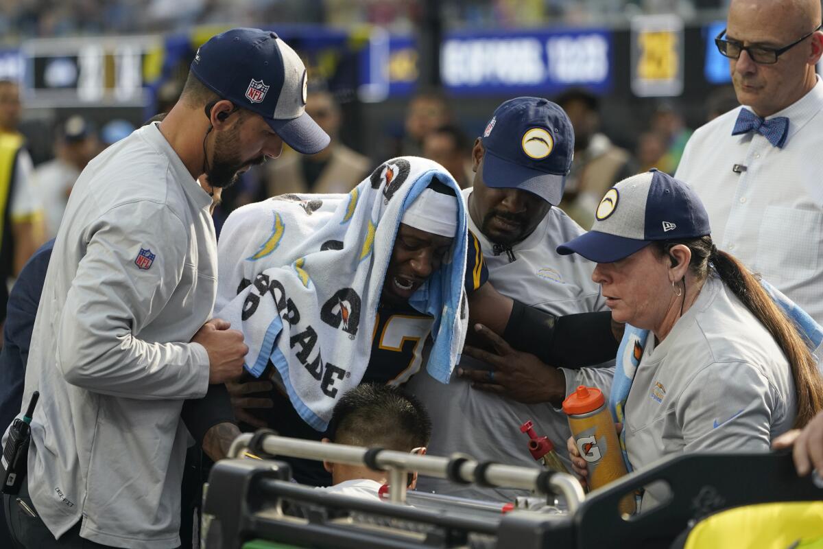 Chargers cornerback J.C. Jackson (27) grimaces in pain as he is put on a cart after injuring his knee against Seattle.