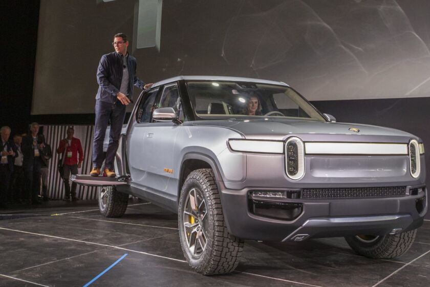 LOS ANGELES, CALIF. -- TUESDAY, NOVEMBER 27, 2018: RJ Scaringe, founder and CEO of Rivian stands on a step for photographers during the world premier of their Rivian R1T electric truck pictured, and R1S electric SUV, not pictured, which are billed as the world?s first electric adventure vehicles during media preview days at the LA Auto Show at the LA Convention Center in Los Angeles, Calif., on Nov. 27, 2018. (Allen J. Schaben / Los Angeles Times)