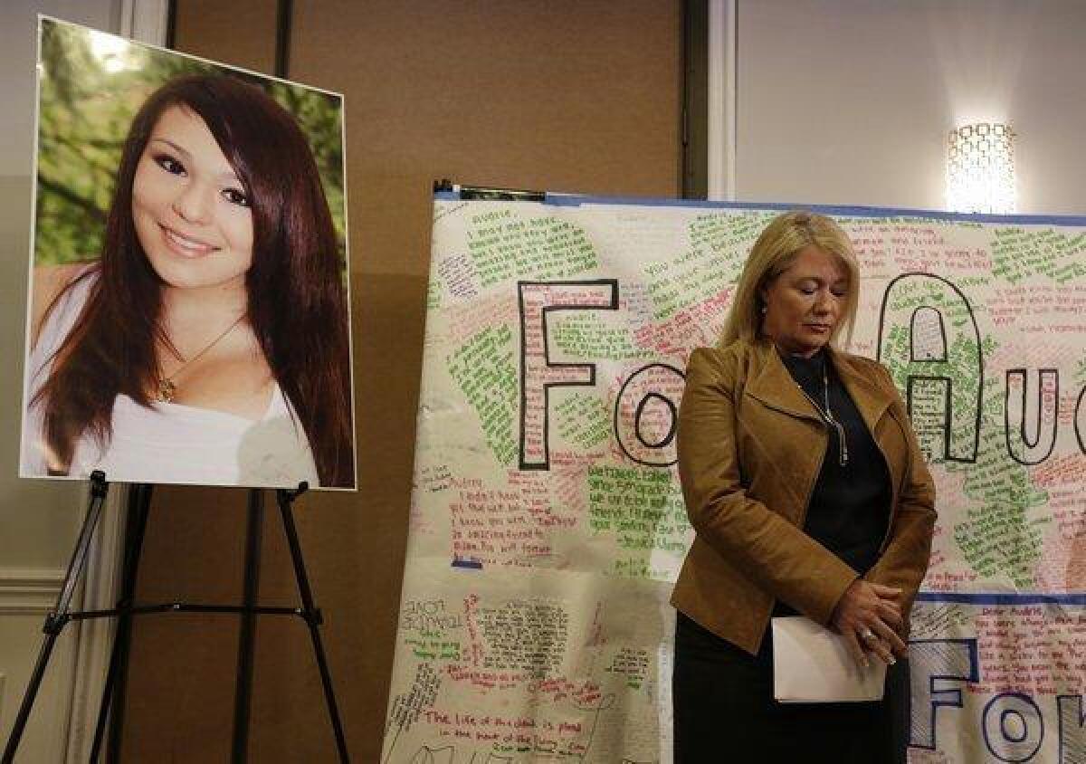Sheila Pott, mother of Audrie Pott, who committed suicide after a sexual assault, stands by a photograph of her daughter and message board during a news conference in April.