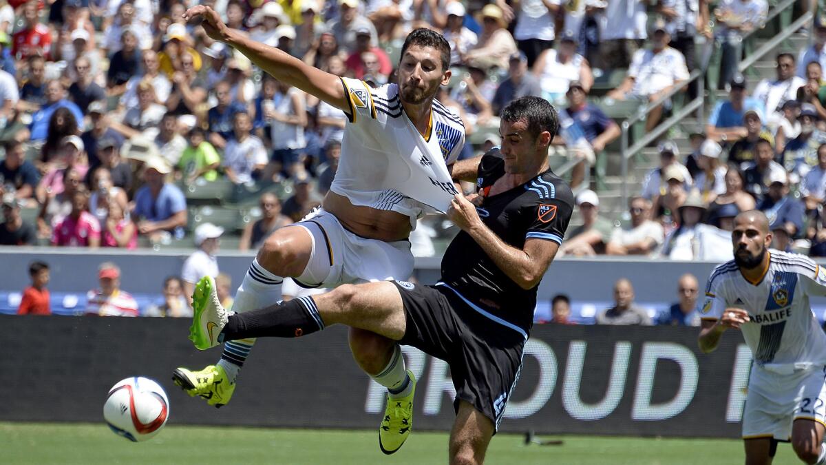 Galaxy defender Omar Gonzalez gets his shirt pulled by New York City's Andrew Jacobson as they battle for possession of the ball during an MLS game on Aug. 23.