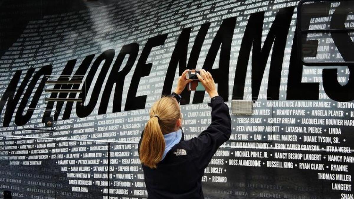 A photo is taken of a bus bearing some of the more than 6,000 names of people killed by gun violence since the massacre in Newtown, Conn.