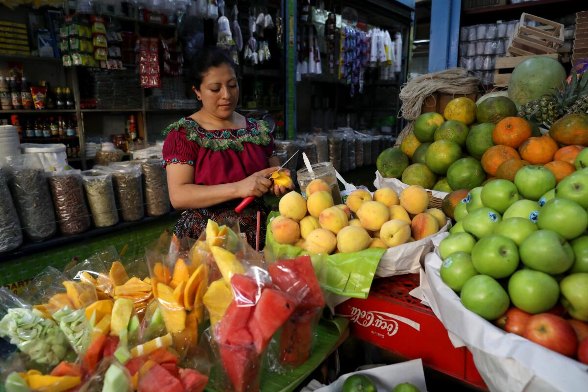 Anabella Juarez prepares cut mango in the Central Market in Guatemala City.