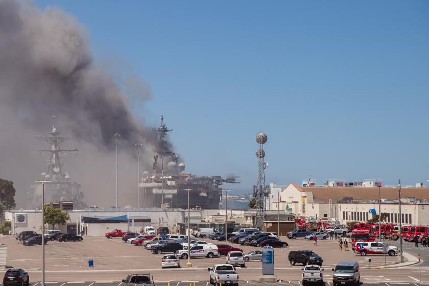 View of naval ship, USS Bonhomme Richard in the distance on fire from outside the naval base in San Diego, California on July 12, 2020.