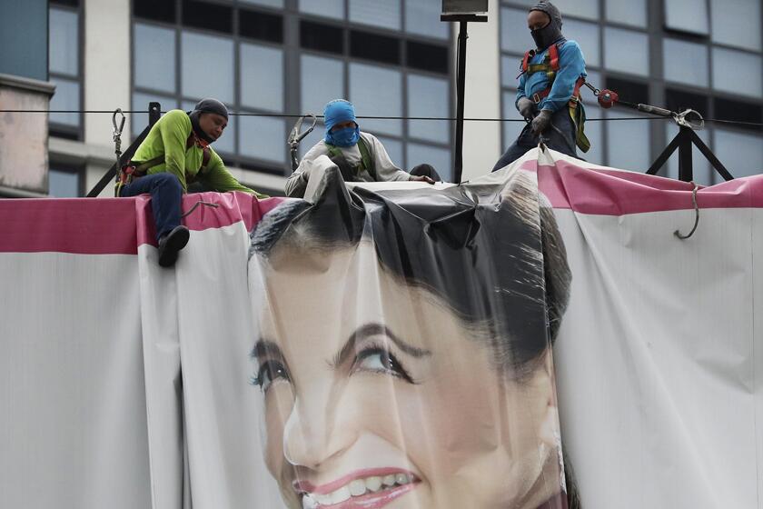 Workers in Manila fold up a billboard on Thursday in preparation for an expected typhoon.