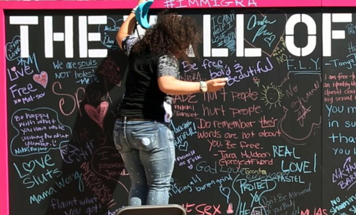People write on The Wall of No Shame as hundreds gathered at Pershing Square for SlutWalk, an anti-slut-shaming event put on by model Amber Rose in Los Angeles on Oct. 4, 2015.