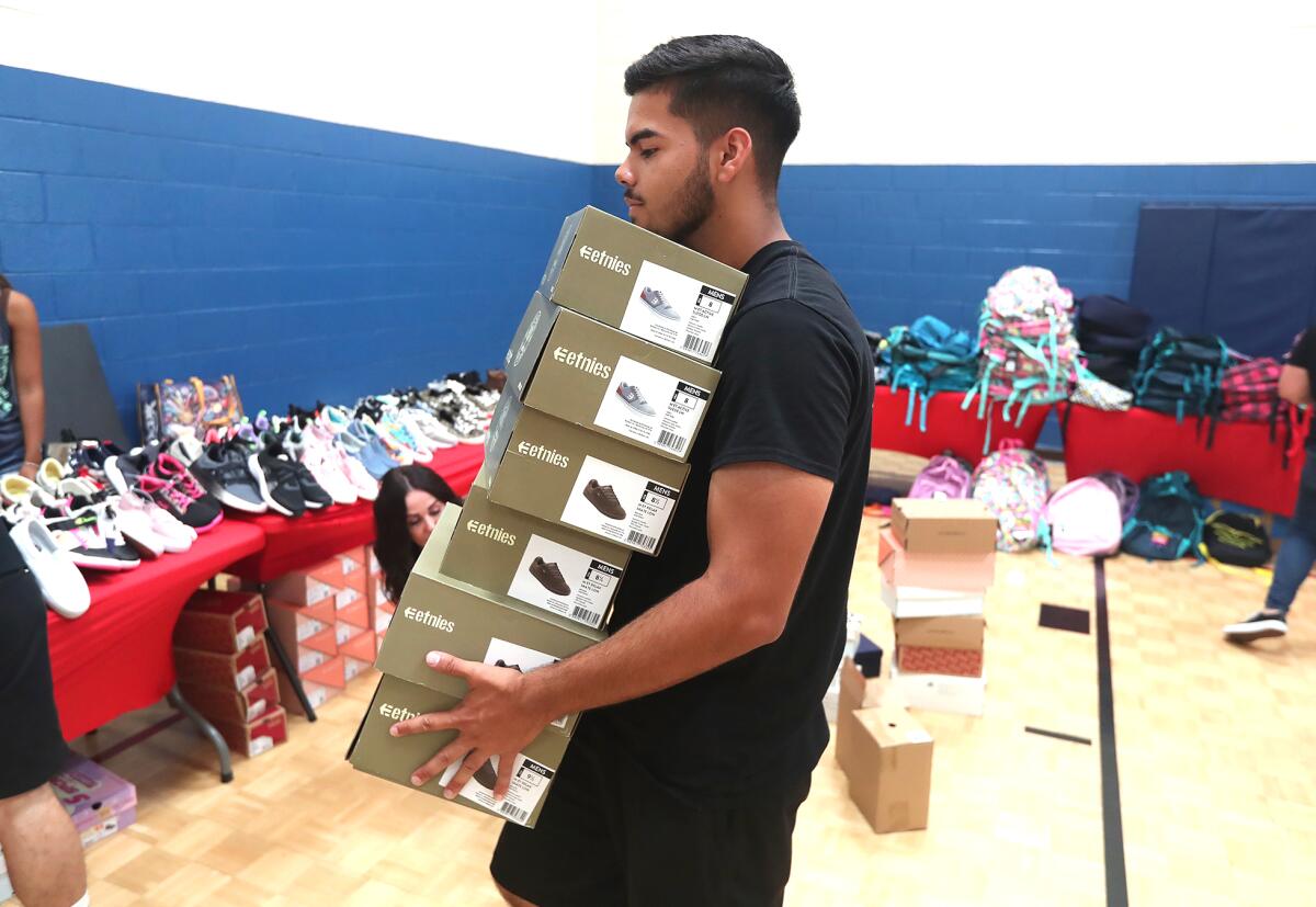 Volunteer Ray Ordaz lifts boxes of new shoes.