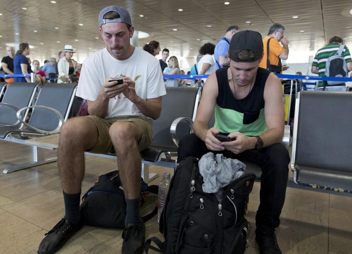 U.S. travelers at Tel Aviv airport on Wednesday try to figure out how to get home after U.S. flights to and from Israel were grounded for a second day.