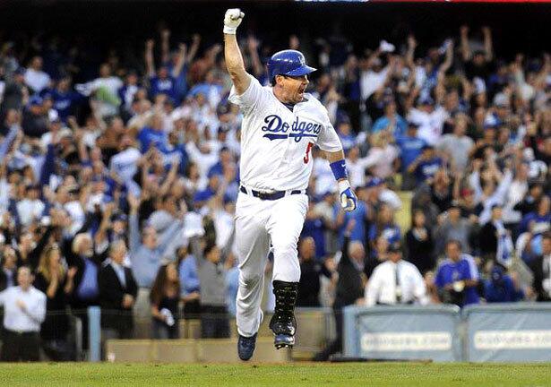 Dodgers pinch-hitter Mark Loretta pumps his fist after delivering the game-winning hit against the Cardinals in Game 2 on Thursday.